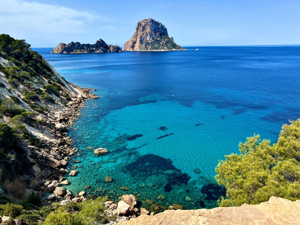 Ibiza's bright turquoise waters with Es Vedra in the distance.