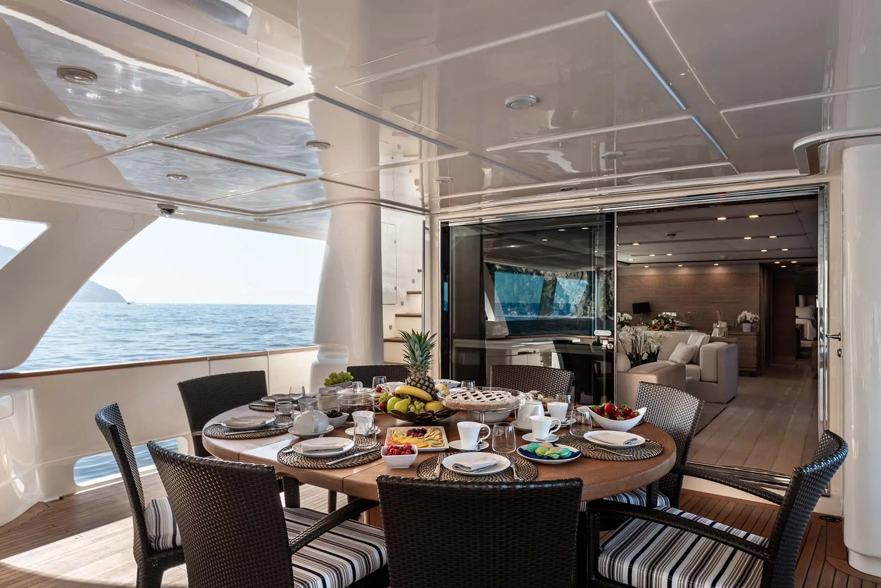 Exterior dining table and chairs on the deck of the superyacht Musica Musica