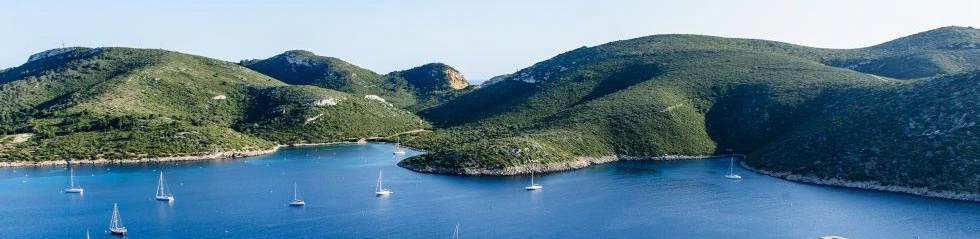 Bright blue waters with yachts in it cruising around the coast on a sunny