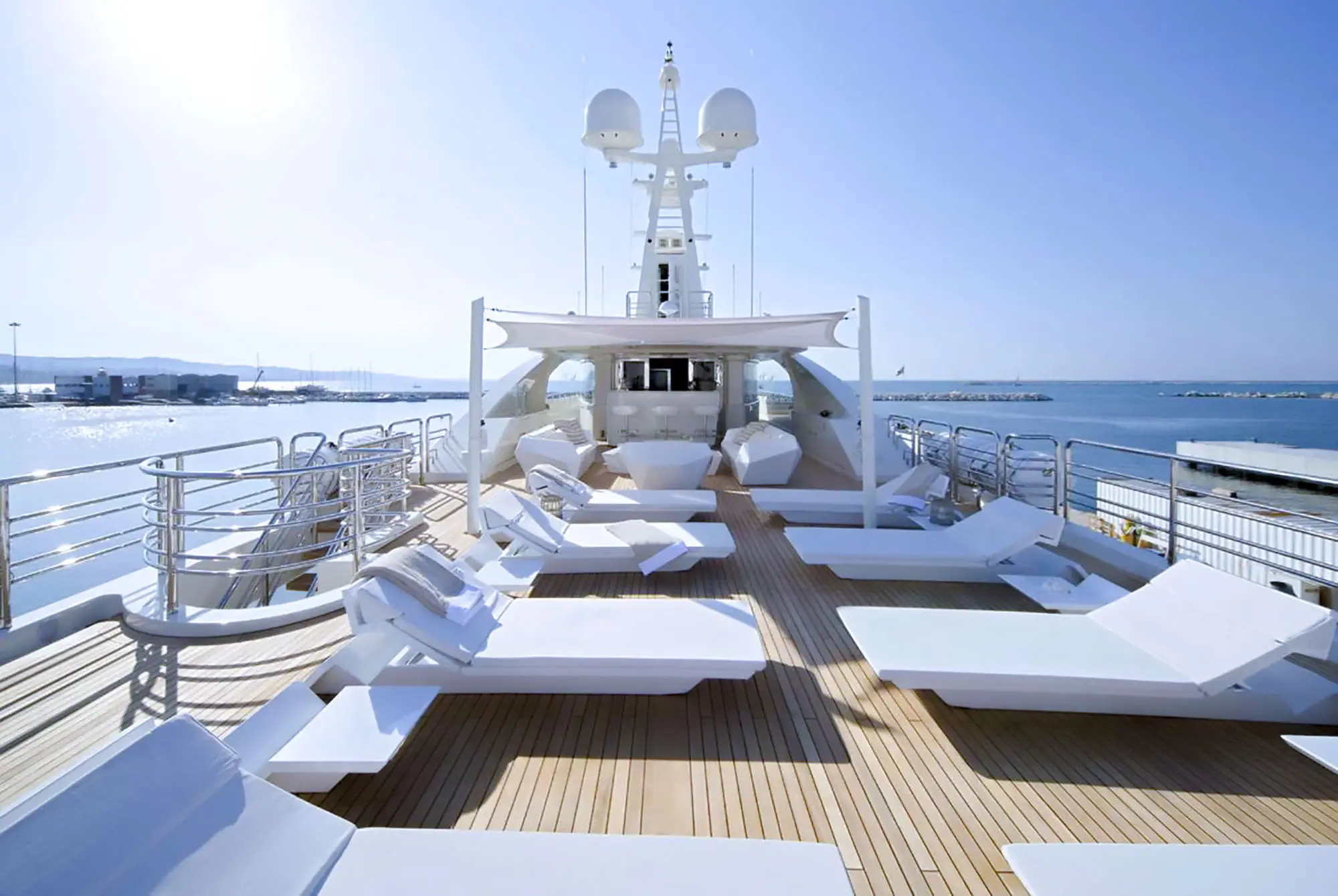 The exterior deck of the Light Holic with sun beds and the sun shining.