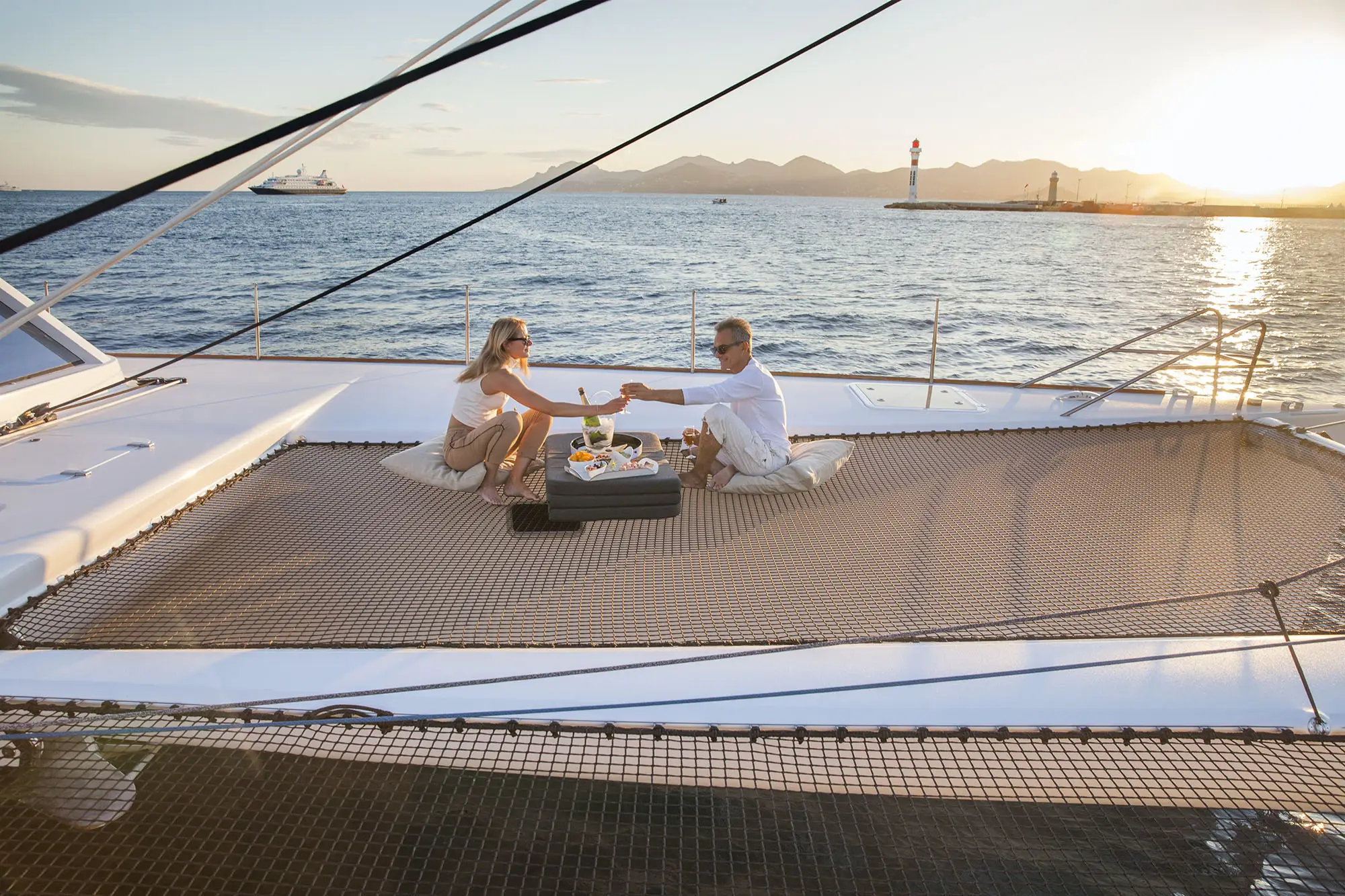 A man and woman enjoying a drink on the Taj Catamaran.
