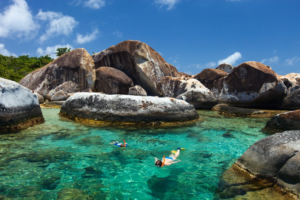 Two people snorkelling in the turquoise waters at the Virgin Gorda Rocks in British Virgin Islands.