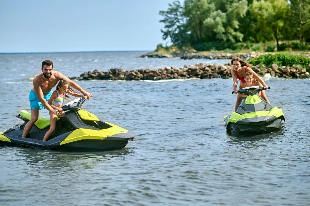 Parents and children enjoying a jet ski by a luxurious island.