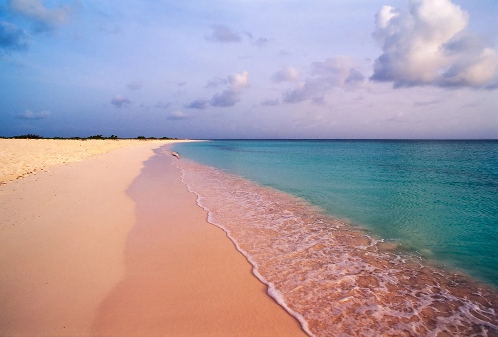 A beach in Anegada where turquoise waters meet pink sands.