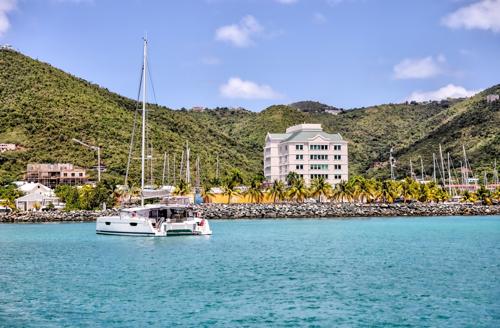 Tortola harbour with a yacht on blue waters on a clear day.