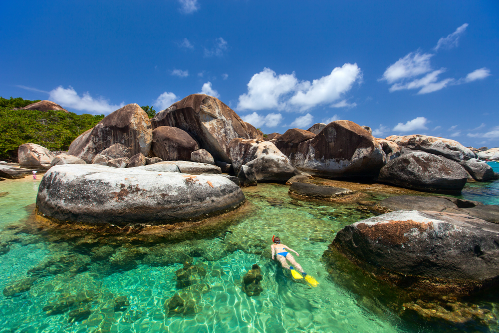 A woman snorkelling in between the Baths of Virgin Gorda.