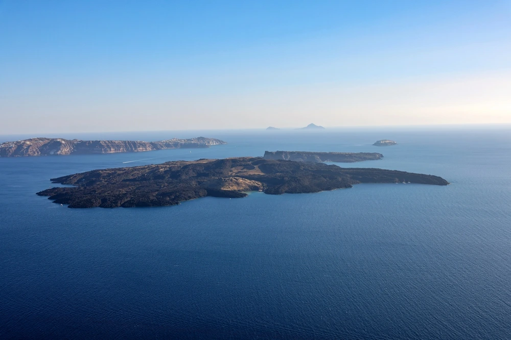 The Cyclades surrounding by deep blue waters under a clear sky.