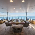 The outdoor dining table and chairs on the Moncada's motor yacht R23's deck.